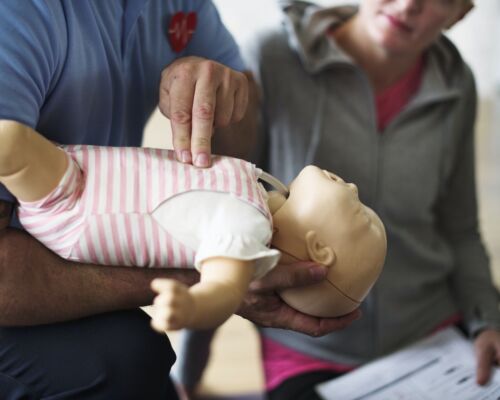 CPR first aid training on a doll infant